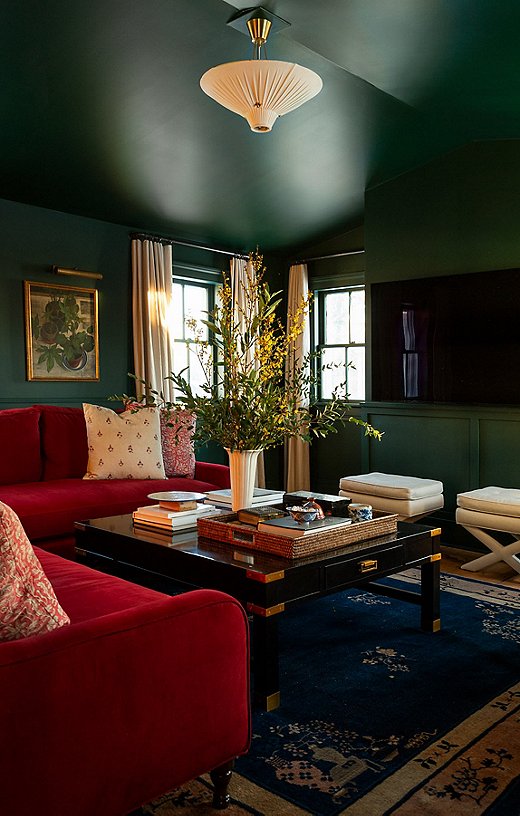 Designers Keren and Thomas Richter of White Arrow painted the walls of their home’s movie room dark green to help camouflage the TV. Photo by Thomas Richter.
